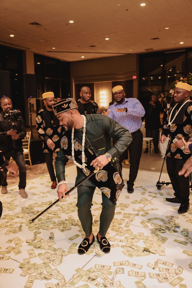 Groom Dancing with his Cane Igbo Wedding while Groomsmen Money Spraying him