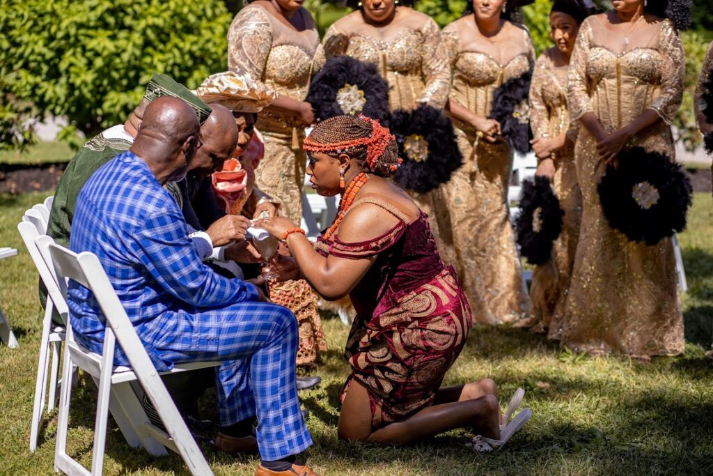 The Bride Kneeling in front of her Father During Wine Carrying Ceremony Traditional Igbo Wedding
